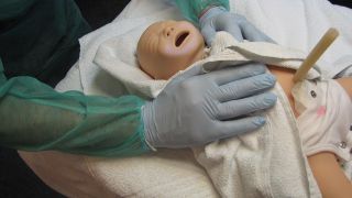 Neugeborenenpuppe wird eingewickelt