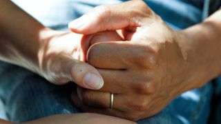 Ehepaar hält Händchen im Krankenbett