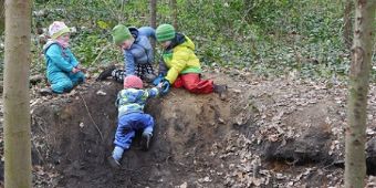 Unsere altersgemischten Gruppen Bild: Größere Kinder einer altersgemischten Gruppe helfen einem kleineren Kind