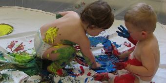 Bild: Krippenkinder beim Spiel mit Farben