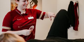 Physiotherapie Einzel Bank Physiotherapeutin behandelt am Knie