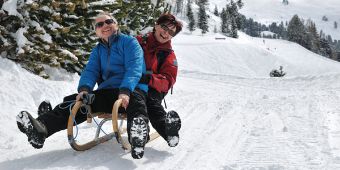 Paar auf Schlitten im Schnee