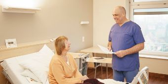 Das Bild zeigt einen Arzt im Gespräch mit einer Patientin