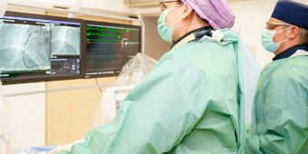 Das Bild zeigt zwei Kardiologen bei einem Eingriff im Herzkatheterlabor