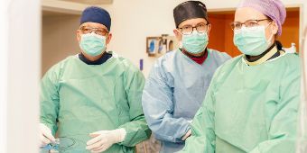 Das Bild zeigt drei Kardiologen im Herzkatheterlabor