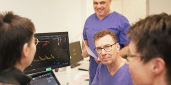Das Bild zeigt drei Kardiologen bei der Besprechung eines Herzultraschalls mit der Patientin