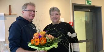 Das Bild zeigt den Geschäftsführer Jörgen Wißler bei der Übergabe eines Blumenstraußes an die Pfllegedienstleitung Karin Schlüter
