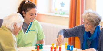 Zwei Patientinnen spielen mit einer Therapeutin Mensch Ärgere Dich Nicht