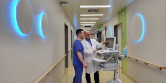 Das Motiv zeigt den Ärztlichen Leiter und eine Pflegefachkraft auf dem Flur der Intensivstation. An den Wänden sieht man die neue Tagesbeleuchtung im Rahmen des Delir-Managements zur Delir-Prävention.