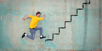 Bild: Mann spingt eine imaginäre Treppe hoch