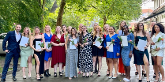 Gruppenfoto von junge Menschen in schöner Gaderobe mit Ausbildungszeugnissen in der Hand