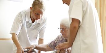 Pflegeexpertin Geriatrie Zwei Pflegerinnen mit Patientin