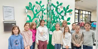 Freuen sich: die Kinder der zweiten Klasse vor dem „Danke-Baum“, Zweite Klasse der Worthschule zu Besuch in der Asklepios Harzklinik Goslar  Schüler:innen schmücken Danke-Baum mit selbst gestalteten Festtags-Botschaften •	Es sind Bilder, Worte der Wertschätzung für die Mitarbeitenden   
