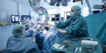 Neuro Chirugie, OTA Das Bild zeigt den Operationssaal der Neurochirurgie. Eine OTA assistiert dem Chirurgen.