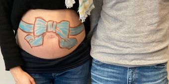 FOTO: Der mit einer blauen Schleife bemalte Bauch einer Schwangeren
