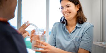 Eine Therapeutin führt logopädische Übungen mit einem Patienten durch