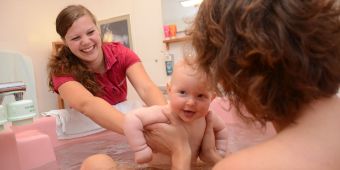 Hebamme mit Baby Baby Wanne übergabe an Mutter72