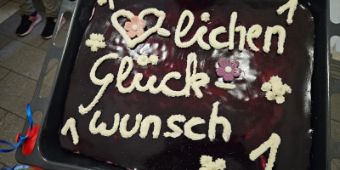 Das Bild zeigt einen Kuchen mit der Aufschrift: Herzlichen Glückwunsch. 