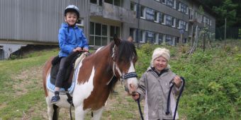 Tag der offenen Tür Ponyreiten Das Motiv zeigt zwei Kinder auf einem Pony