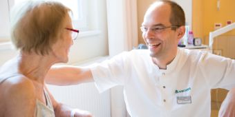 Das Bild zeigt Herrn Richter im Gespräch mit einer geriatrischen Patientin
