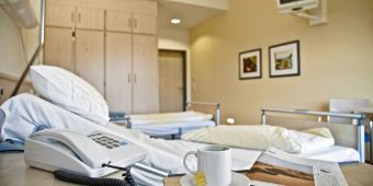 Das Bild zeigt den Blick in ein Patientenzimmer mit dem Bett im Vordergrund.