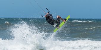Das Motiv zeigt einen Kitesurfer im Meer.