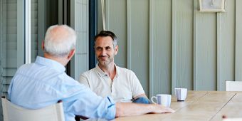 Das Bild zeigt eine Gesprächssituation zwischen 2 Menschen an einem Esstisch