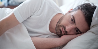 Depressiver Mann liegt im Bett Foto: Depressiver Mann liegt im Bett