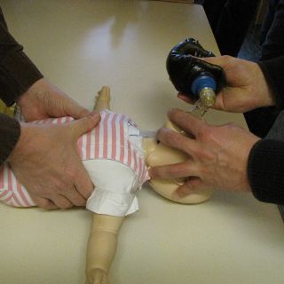 Zwei Helfer reanimieren eine Babypuppe