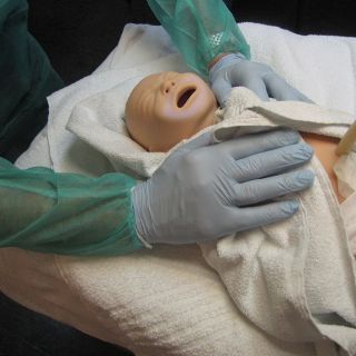 Neugeborenenpuppe wird eingewickelt