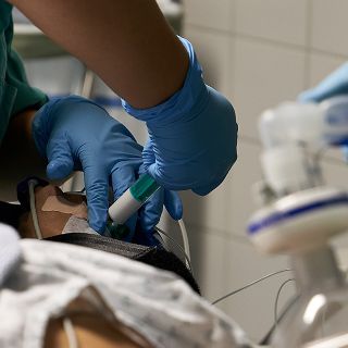 Einem narkotisiertem Patienten wird von einem Anästhesietechnischen Assistenten ein Schlafmittel verabreicht