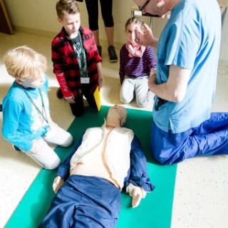 Arzt mit Kindern und einer Puppe