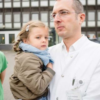 Arzt mit Kind auf dem Arm