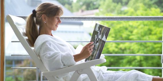 Bild: Frau im Stuhl liest Magazin