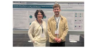 PD Dr. med. Georgia Schilling und Elias Bidinger vor dem präsentierten Poster.