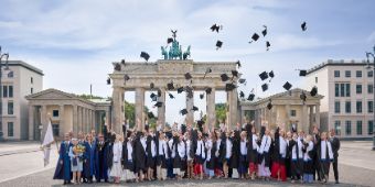 Der traditionelle Hutwurf vor dem Brandenburger Tor bildet den feierlichen Abschluss der Diplomverleihung.