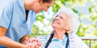 Bild: Ancoris-Tag 2022 - geriatrische Patientin lächelt ihre Pflegefachkraft an