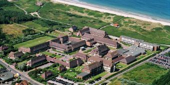 Das Bild zeigt eine Luftaufnahme der Nordseeklinik mit der Nordsee im Hintergrund.