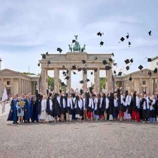 Der traditionelle Hutwurf vor dem Brandenburger Tor bildet den feierlichen Abschluss der Diplomverleihung.