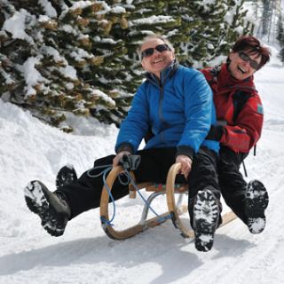 Paar auf Schlitten im Schnee