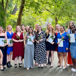 Gruppenfoto von junge Menschen in schöner Gaderobe mit Ausbildungszeugnissen in der Hand