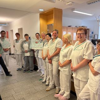 Zum Internationalen Tag der Pflege am 12. Mai setzen die Geschäftsführung und die Pflegedirektion ein besonderes Zeichen der Anerkennung und Wertschätzung: Alle Stationen und Teams der Asklepios Harzkliniken an den Standorten Bad Harzburg und Goslar sowie der Asklepios Klinik Schildautal in Seesen erhalten einen finanziellen Beitrag für ein gemeinsames Team-Event geschenkt. Die Teamleitungen bekamen einen symbolischen Scheck. Die Höhe des Betrags richtet sich nach der Anzahl der Mitarbeitenden im jeweiligen Team, insgesamt sind es knapp 10.000 Euro. Asklepios Harzkliniken-Pflegemanagerinnen Marika Strube, Amanda Körber und Harzkliniken-Klinikmanager Dorian Denner überreichten die Geldgeschenke in den Harzkliniken, Annett Dziuba, Pflegedirektorin in der 