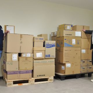 Das Motiv zeigt Geschäftsführer Thomas Piefke und eine Mitarbeiterin mit den Kartons der Spendenaktion.