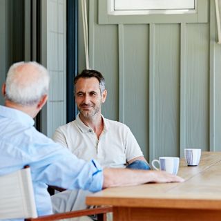Das Bild zeigt eine Gesprächssituation zwischen 2 Menschen an einem Esstisch