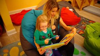 Bild: Kind und Erzieherin beim Lesen