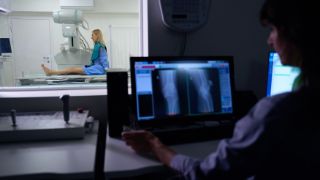 Das Motiv zeigt eine Patientin in der Radiologie beim Knie röntgen