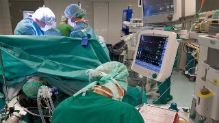 Eine Anästhesietechnische Assistentin dokumentiert während einer Operation