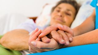 Bild: Pflegerin hält Patienten die Hand