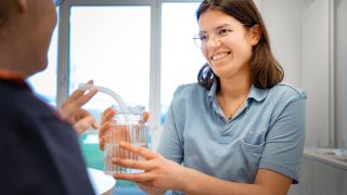 Eine Therapeutin führt logopädische Übungen mit einem Patienten durch