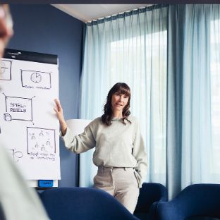 Therapeutin erklärt Patienten etwas an einem Whiteboard